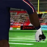 アメリカンフットボールのフィールドでプレイヤーがボールをキックしている瞬間。