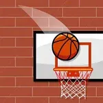 バスケットボールが赤レンガの壁に取り付けられたバスケットボードに向かって飛んでいる。