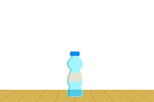 青いキャップの水色のプラスチックボトルが木の床の上に置かれている。