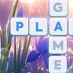 花と光の背景に、ブロックの文字「PLAY」と「GAME」がクロスして配置され、指が「Y」を指している画像。