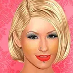 金髪でショートヘアの女性がピンクの花柄の背景の前に微笑んでいる。