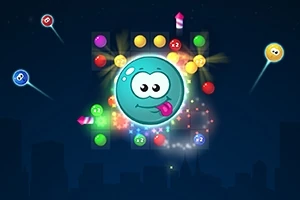 青い背景に、大きな青い球体のキャラクターが真ん中にあり、周囲にカラフルな弾やキャンディなどが浮かんでいる。