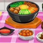 ピンクのテーブルクロスの上に鍋料理と様々な料理と緑茶が並んでいる。