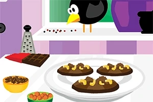 窓辺に鳥がいるキッチンのテーブルには、チョコレートとナッツがトッピングされたクッキーが皿にのっている。