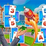 金髪の女性がカードとロケットが飛んでいるカラフルな背景の前に立っている。