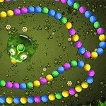 カラフルなボールが連なる線が迷路のように配置され、中央に緑色のカエルのキャラクターがいる。