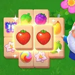 緑の背景に、いちごや果物が描かれたタイルと、花の飾りをつけた帽子をかぶった笑顔のノーム。