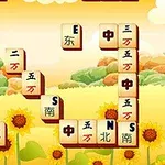 黄色い背景にひまわりが描かれ、麻雀牌が散らばっている風景。