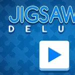 青色の背景に大きな白い三角形の再生ボタンと、「JIGSAW DELUXE」というテキスト、白いパズルピースのアイコンがあります。