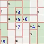 赤い枠で区切られた緑と白のグリッドに青い数字が配置されているパズルの画像。
