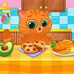 オレンジ色の猫がキッチンでアボカド、ソーセージ、揚げ物の料理が並べられたテーブルに座っている。