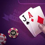紫のテーブルの上に置かれたトランプのジャックとエースのカードを持つ手と、そばにある1000と10Kのポーカー用チップ。