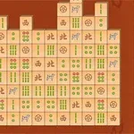 茶色の背景に、緑と赤の模様が描かれた麻雀タイルが配置されています。