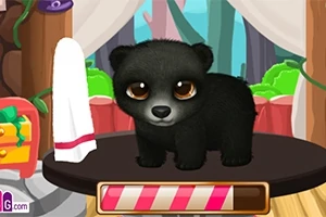 黒いクマの子供が、室内のテーブルの上に立っている。
