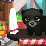 黒いクマの子供が、室内のテーブルの上に立っている。
