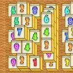 カラフルな数字が描かれた複数の麻雀牌が、木目調の背景の上に並べられている。