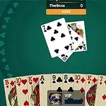緑色のテーブル上に並べられたトランプの手札と中央に置かれたカード。