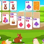 草原の風景の中にトランプが並べられ、ウサギやニワトリが描かれたカードが配置されています。