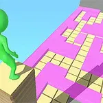 緑色のキャラクターが積み重ねた板の上に立ち、ピンクと黄色のグリッドパターンの道路を見渡している。
