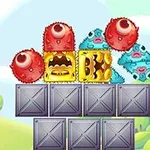 赤い目玉のモンスターと黄色と青のブロックが金属の箱の上に配置されているカラフルなイラスト。