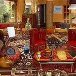 豪華な絨毯が敷かれた部屋にアンティーク調の家具や装飾品が散らばっている様子。
