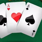 緑のテーブルの上に並んだスペード、ハート、クラブのエースのカード。