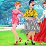 公園の背景でカラフルなドレスを着た3人の女性がポーズをとっている。