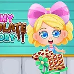 金髪の女の子がチョコレートの箱を持っているイラストで、背景に「Yummy Chocolate Factory」という文字がある。
